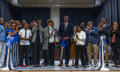 Bruns Avenue Elementary Principal Dr. Nathan Currie cuts a ribbon during the school's dedication.